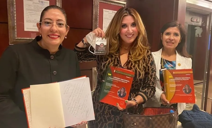 La Dra. González Obregón con dos colegas que sostienen ejemplares autografiados del Código comentado